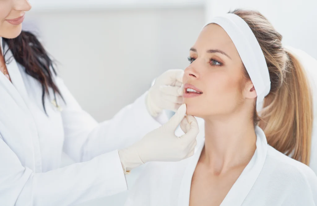 A skincare expert examines a client’s face during a Diamond Glow Facial consultation.