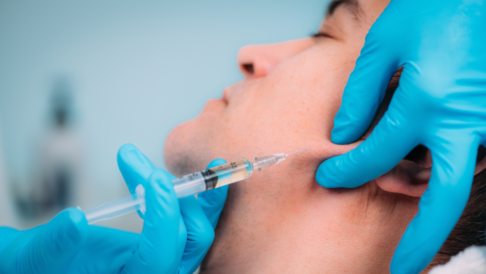 Male patient receiving jawline injectables.